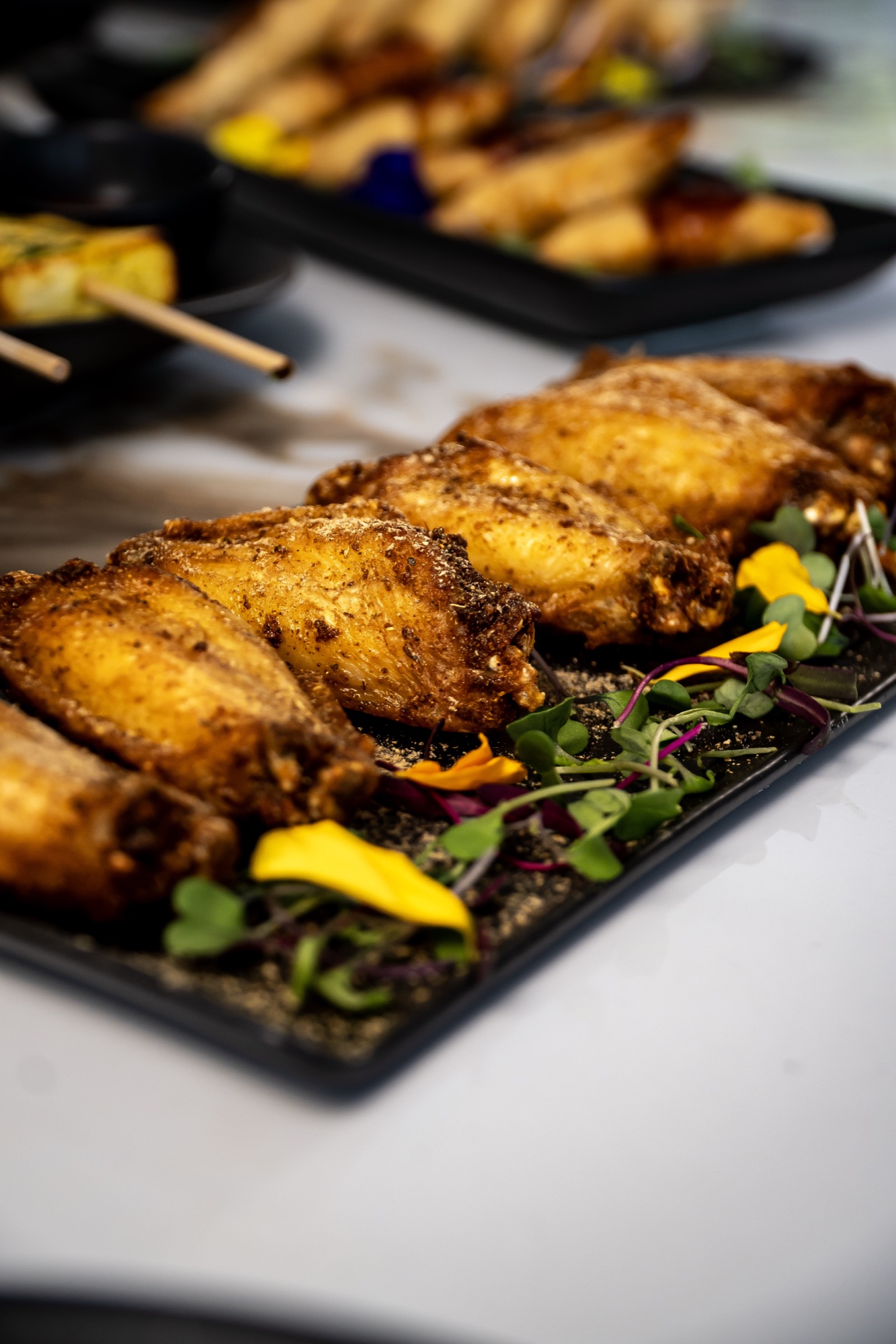 Spiced fried wings with edible flowers