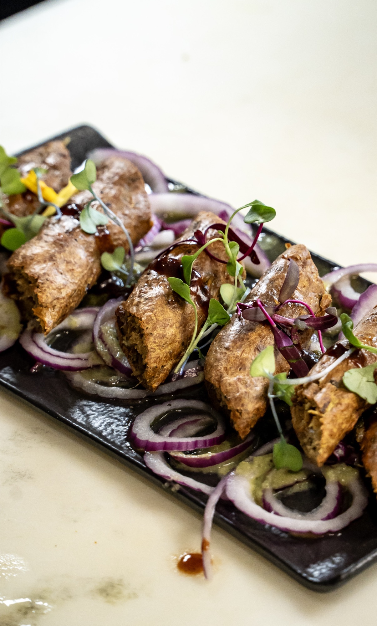 Seekh kebab with red onion and microgreens